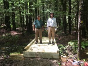 Tom Bratko and Ron Paradise standing on a completed wooden bridge at Rome Conservation Area